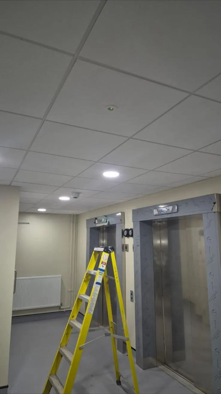 Suspended tile ceiling with downlights in a lift lobby