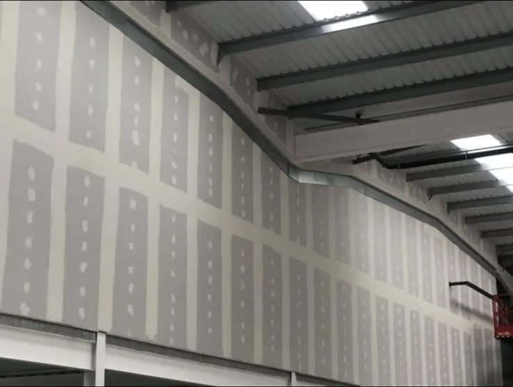 Tall plasterboard wall taped and jointed under a steel portal frame roof