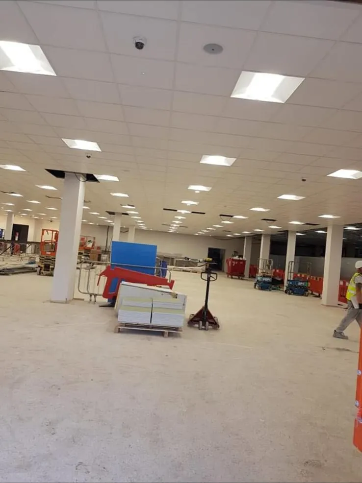 Completed lay in grid suspended ceiling with LED panels across a large open plan floor