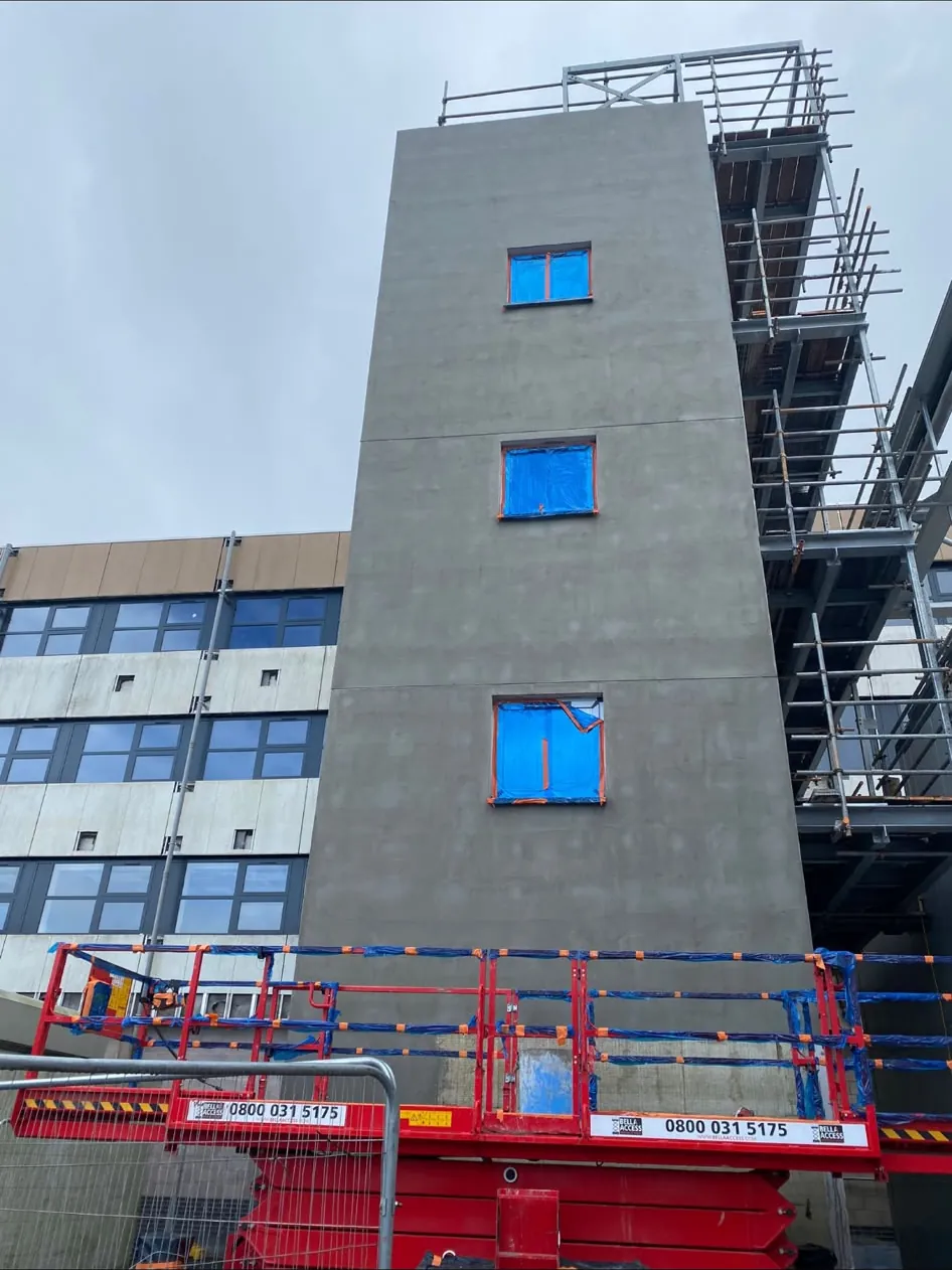 Four storey SFS framed stair tower with sheathing board and render, windows taped ready for glazing